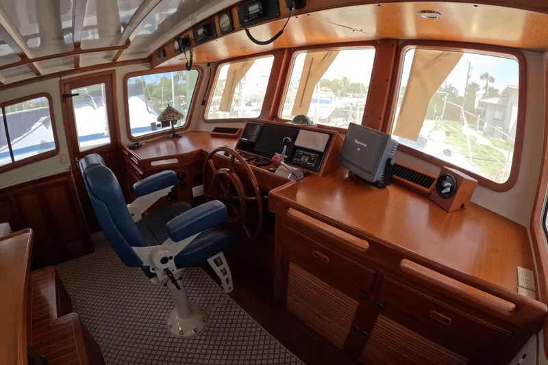 Slide: The Image of Interior of 1999 Kadey-Krogen 48 North Sea yacht with wooden helm and blue captain's chair. - 24