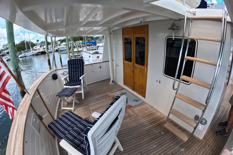 Slide: The Image of 1999 Kadey-Krogen 48 North Sea yacht deck with seating, ladder, and marina view. - 46