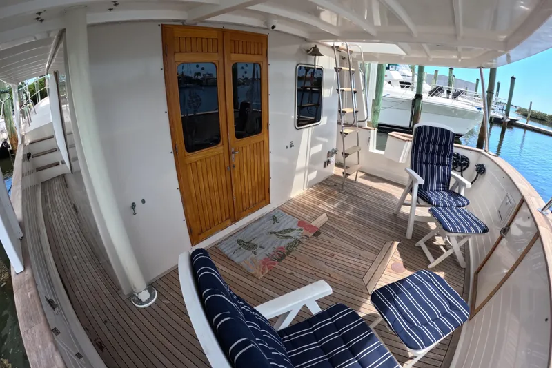 Slide: The Image of 1999 Kadey-Krogen 48 North Sea yacht deck with striped chairs and wooden doors. - 45