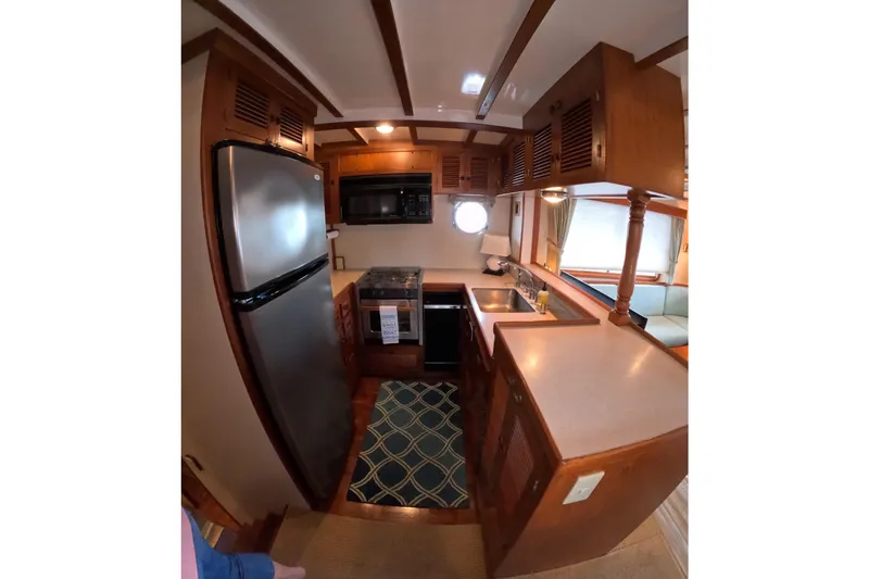 Slide: The Image of 1999 Kadey-Krogen 48 North Sea yacht kitchen with wood cabinetry and modern appliances. - 16