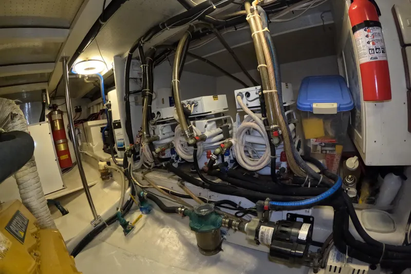 Slide: The Image of Engine room of 1999 Kadey-Krogen 48 North Sea yacht with equipment and fire extinguishers. - 90