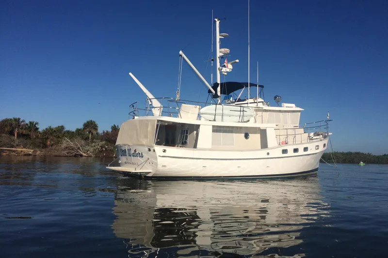 Slide: The Image of Kadey-Krogen 48 North Sea yacht, 1999 model, anchored on calm waters under clear blue sky. - 1