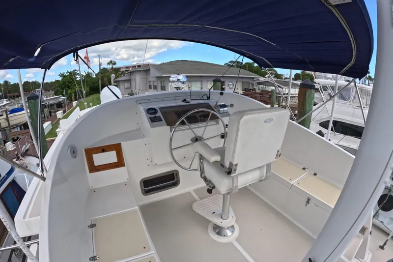 Slide: The Image of 1999 Kadey-Krogen 48 North Sea yacht helm with steering wheel and captain's chair under canopy. - 65