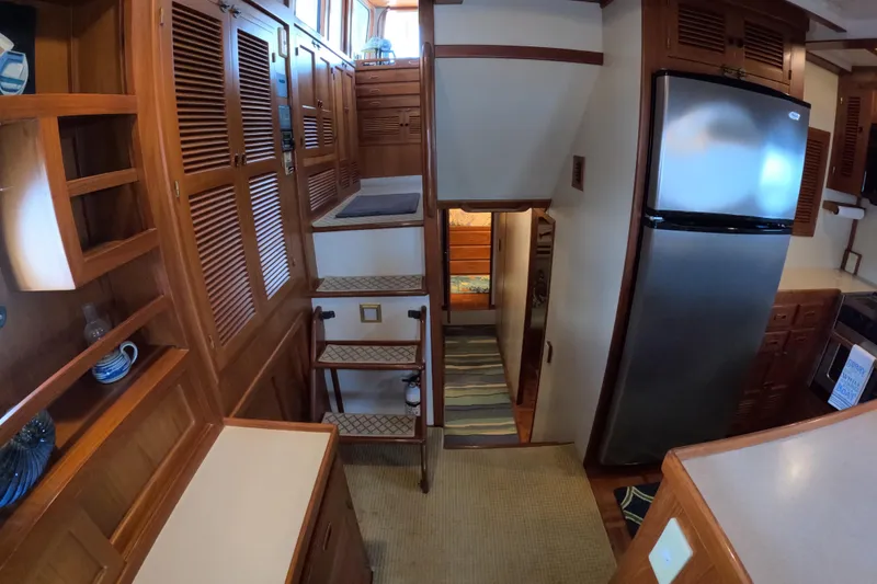 Slide: The Image of Interior of 1999 Kadey-Krogen 48 North Sea yacht with wooden cabinetry and stainless steel fridge. - 19