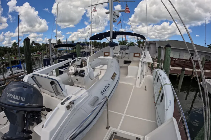 Slide: The Image of 1999 Kadey-Krogen 48 North Sea yacht docked, featuring Yamaha engine and inflatable boat. - 61