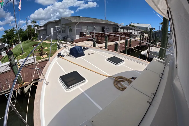 Slide: The Image of Kadey-Krogen 48 North Sea yacht docked, showcasing spacious deck and marina view, 1999 model. - 53