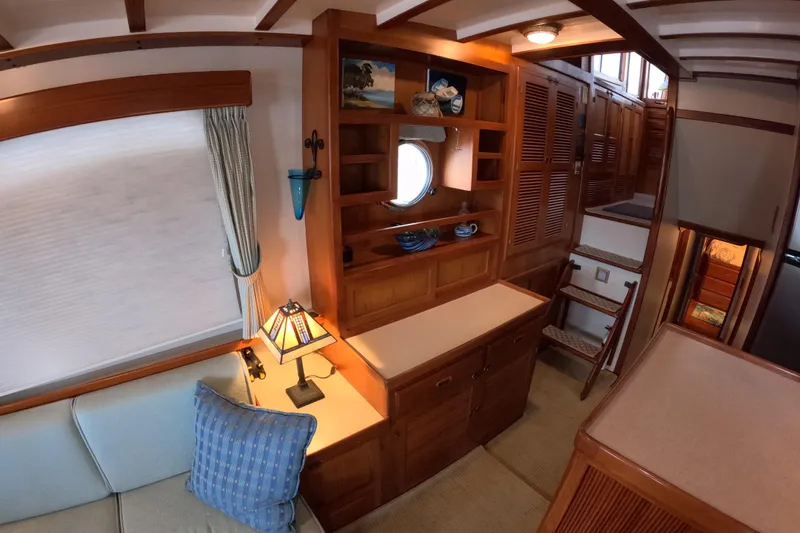 Slide: The Image of Interior of 1999 Kadey-Krogen 48 North Sea yacht, featuring wooden cabinetry and cozy seating. - 18