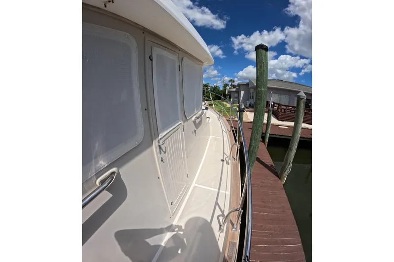 Slide: The Image of 1999 Kadey-Krogen 48 North Sea yacht docked under a clear blue sky. - 58