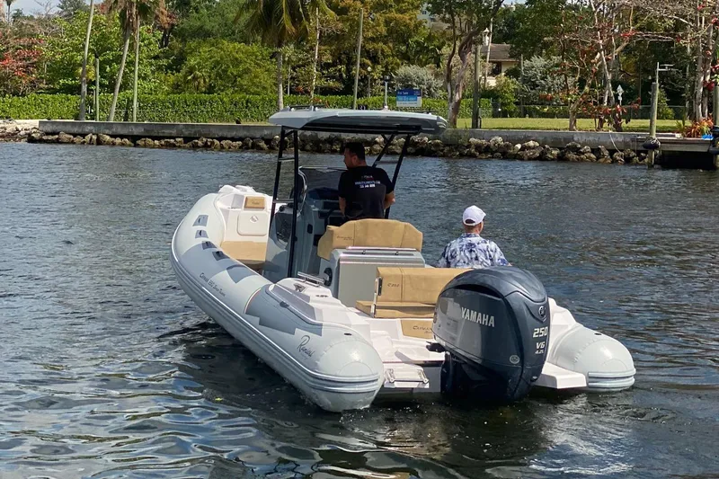 Slide: The Image of 2025 Ranieri Cayman 23.0 Sport Touring boat cruising on a calm waterway. - 1