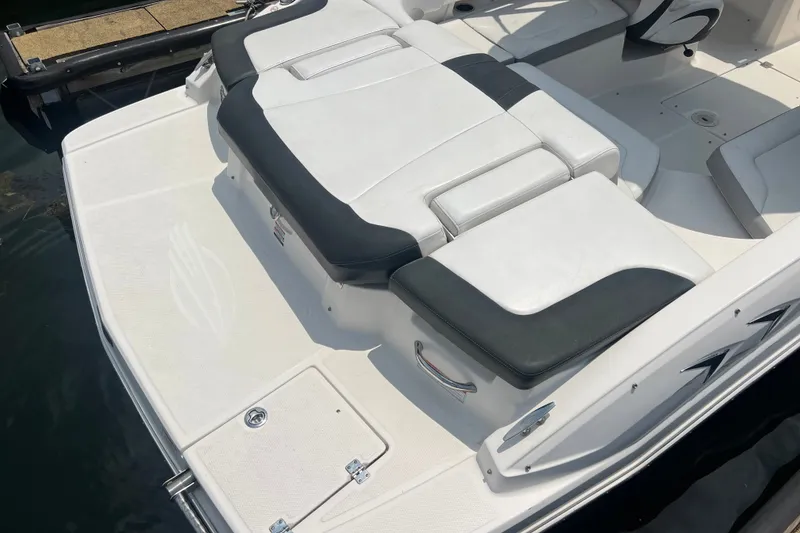 Slide: The Image of 2020 Chaparral 23 SSi boat with white and black seating, docked on water. - 14