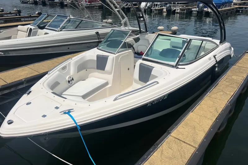 Slide: The Image of 2020 Chaparral 23 SSi boat docked at marina, featuring sleek design and spacious seating. - 15