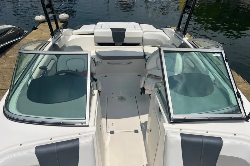 Slide: The Image of 2020 Chaparral 23 SSi boat interior with open cockpit and seating, docked by the water. - 13