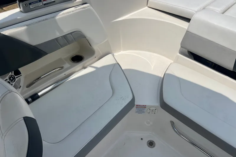 Slide: The Image of Interior seating of 2020 Chaparral 23 SSi boat, featuring white upholstery and cup holder. - 12