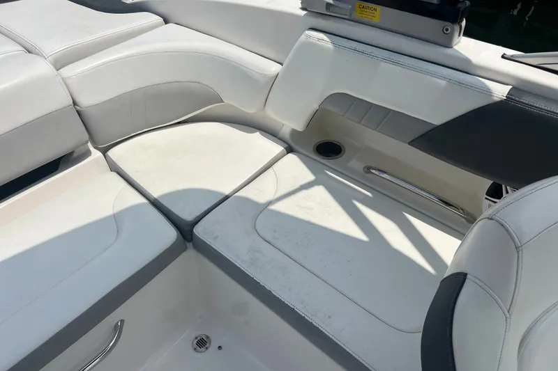 Slide: The Image of 2020 Chaparral 23 SSi boat interior with white cushioned seating and cup holder. - 11