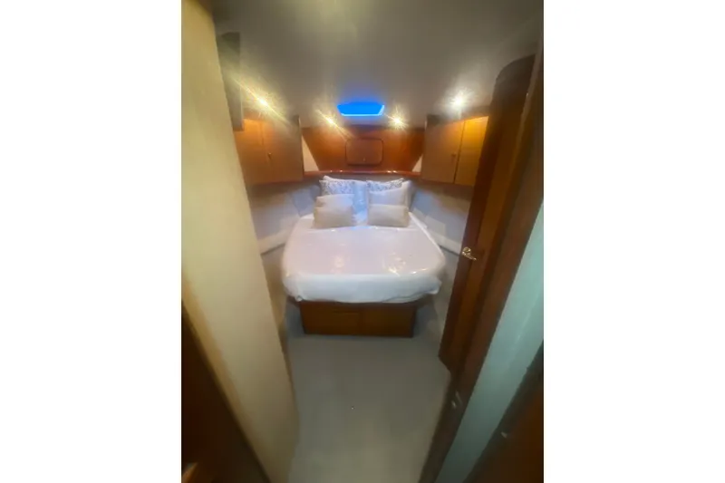 Slide: The Image of Luxurious bedroom interior of 2005 Ocean Yacht 50' Super Sport, featuring cozy bedding and wooden cabinetry. - 17