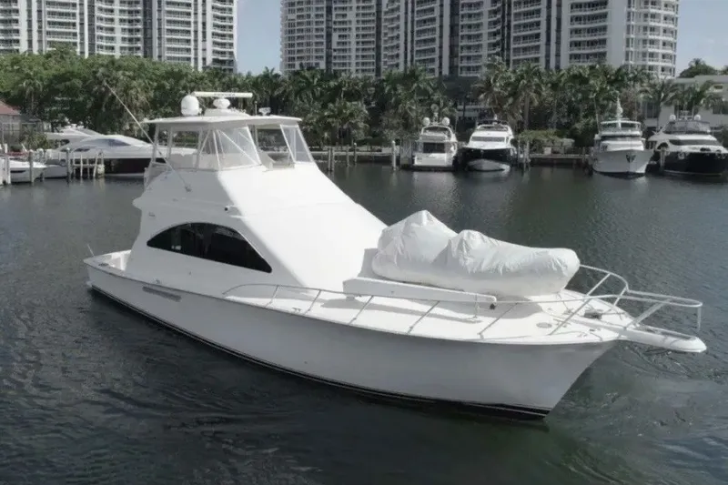 The Image of 2005 Ocean Yachts 50 Super Sport in marina, surrounded by other boats and high-rise buildings. - 0