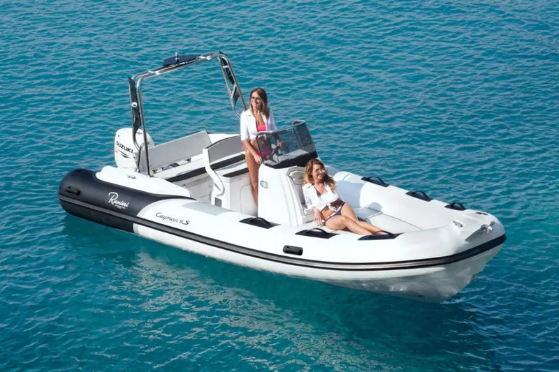 Slide: The Image of 2025 Ranieri CAYMAN 19 Sport boat on clear blue water with two women onboard. - 0