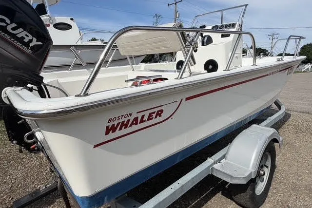 Slide: The Image of 2019 Boston Whaler 150 Montauk boat on trailer, side view with visible branding. - 11