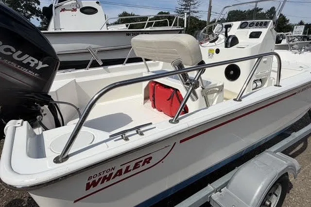 Slide: The Image of 2019 Boston Whaler 150 Montauk boat on trailer, featuring Mercury engine. - 10