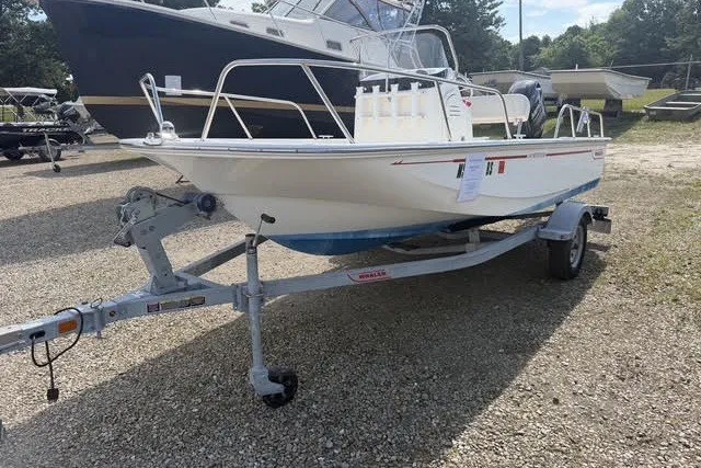 Slide: The Image of 2019 Boston Whaler 150 Montauk boat on trailer in outdoor setting. - 1