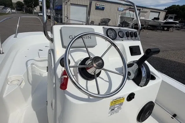 Slide: The Image of 2019 Boston Whaler 150 Montauk boat dashboard with steering wheel and controls. - 7