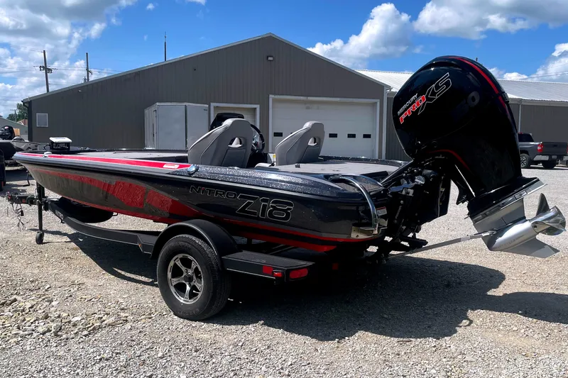 Slide: The Image of A 2024 Nitro Z18 boat with a powerful outboard motor, parked on a trailer in front of a building. - 4