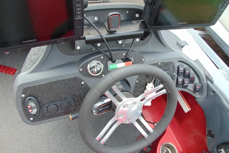 Slide: The Image of Steering console of 2010 Boomeranger 188 boat with Garmin displays and control switches. - 12
