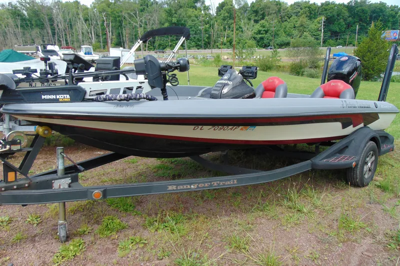 The Image of 2010 Boomeranger 188 boat on trailer, equipped with Minn Kota motor, parked outdoors. - 1