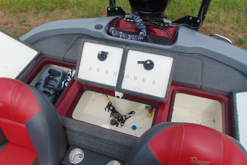 Slide: The Image of Interior of a 2010 Boomeranger 188 boat with red seats and storage compartments. - 10