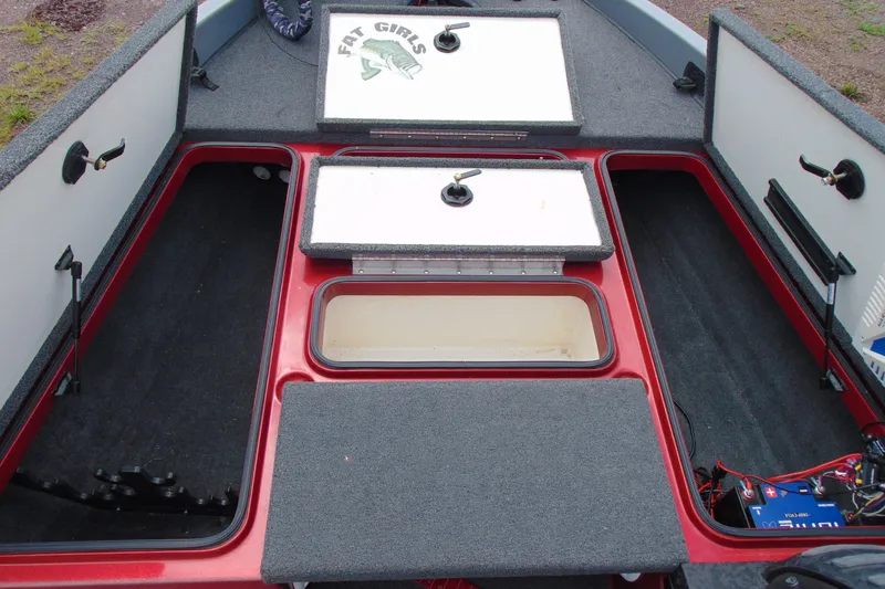 Slide: The Image of Open storage compartments on a 2010 Boomeranger 188 boat, featuring carpeted interiors. - 15