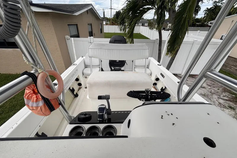 Slide: The Image of 1992 Hydra-Sports 2000 CC boat interior with steering wheel and seating, parked near a house. - 34