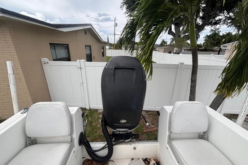 Slide: The Image of 1992 Hydra-Sports 2000 CC boat with outboard motor, parked near a white fence. - 38