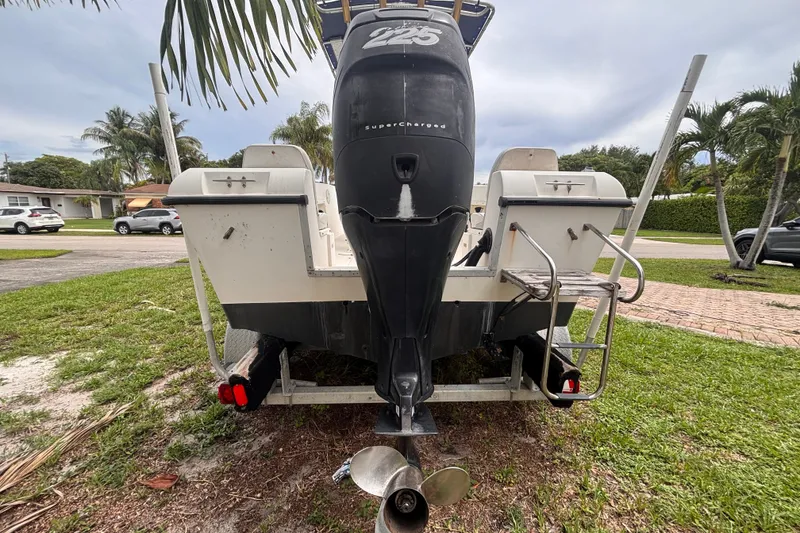 Slide: The Image of 1992 Hydra-Sports 2000 CC boat with powerful outboard motor, parked on grass. - 5