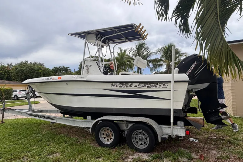 Slide: The Image of 1992 Hydra-Sports 2000 CC boat on trailer, parked outdoors with palm trees in background. - 8