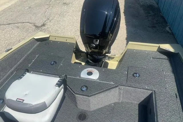 Slide: The Image of 2027 Tracker Pro Guide V-16 WT boat with motor and seating, docked on pavement. - 12