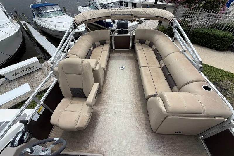 Slide: The Image of 2020 Sun Tracker Party Barge 22 DLX with spacious seating, docked near other boats. - 10