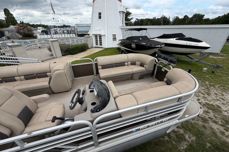 Slide: The Image of 2020 Sun Tracker Party Barge 22 DLX pontoon boat with spacious seating, parked near a lighthouse. - 16