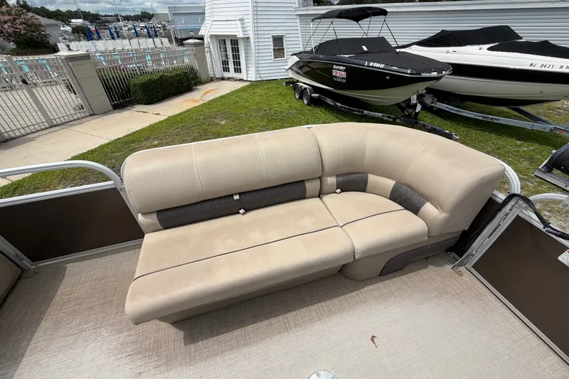 Slide: The Image of 2020 Sun Tracker Party Barge 22 DLX with beige seating, parked near boats. - 5