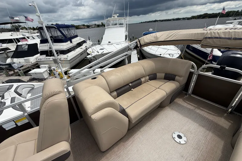 Slide: The Image of 2020 Sun Tracker Party Barge 22 DLX with beige seating at a marina. - 7