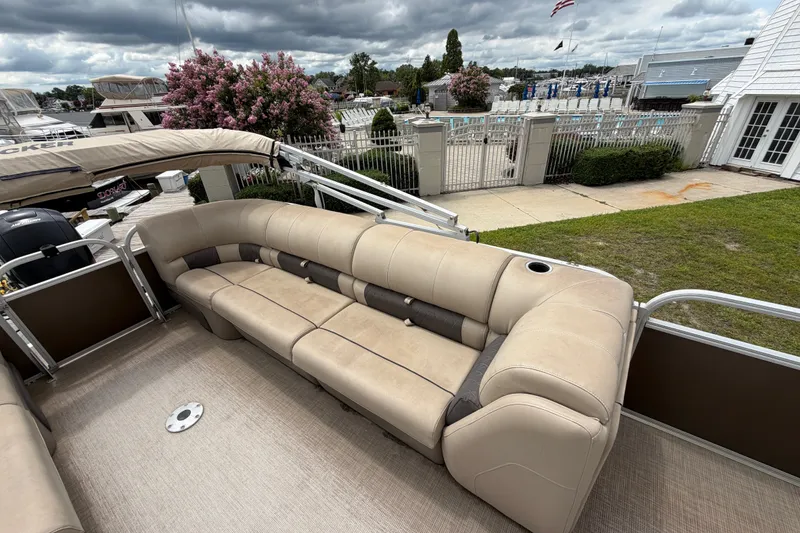 Slide: The Image of 2020 Sun Tracker Party Barge 22 DLX with beige seating, docked near a marina. - 6