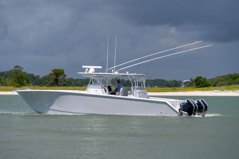 Slide: The Image of 2021 SeaHunter 41 CTS boat cruising on a calm waterway under cloudy skies. - 26