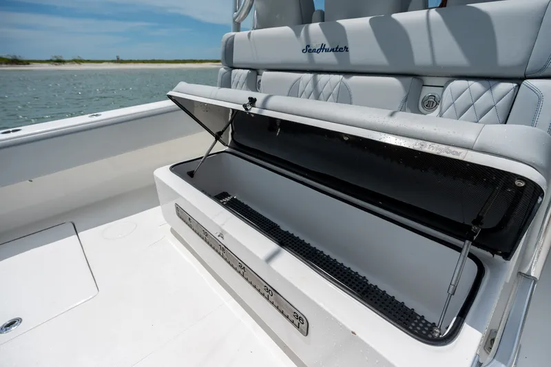 Slide: The Image of 2021 SeaHunter 41 CTS boat with open storage compartment, showcasing luxury seating and coastal view. - 36