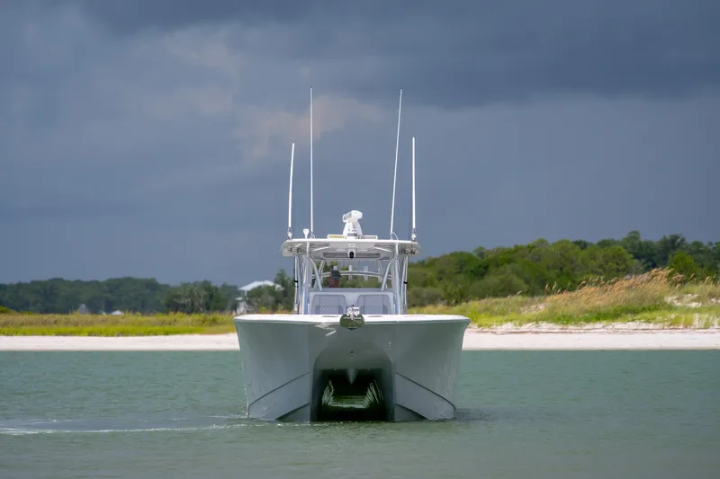 Slide: The Image of 2021 SeaHunter 41 CTS boat navigating near a sandy shoreline under cloudy skies. - 28