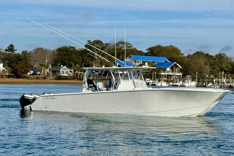 Slide: The Image of 2021 SeaHunter 41 CTS boat cruising on a calm waterway with scenic background. - 5