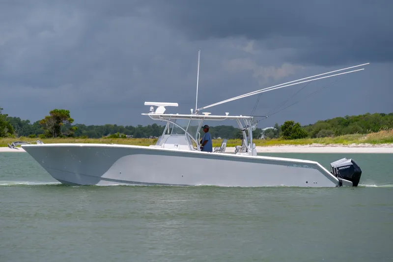 Slide: The Image of 2021 SeaHunter 41 CTS boat cruising on a calm waterway under cloudy skies. - 27