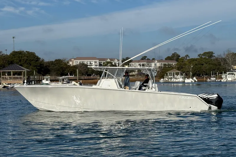Slide: The Image of 2021 SeaHunter 41 CTS boat cruising on calm water near a marina. - 6