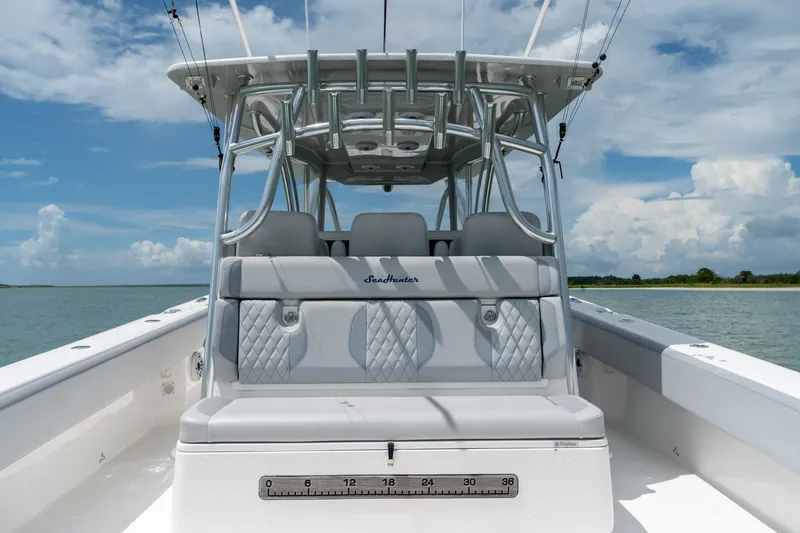 Slide: The Image of 2021 SeaHunter 41 CTS boat interior with cushioned seating, on a calm water backdrop. - 35