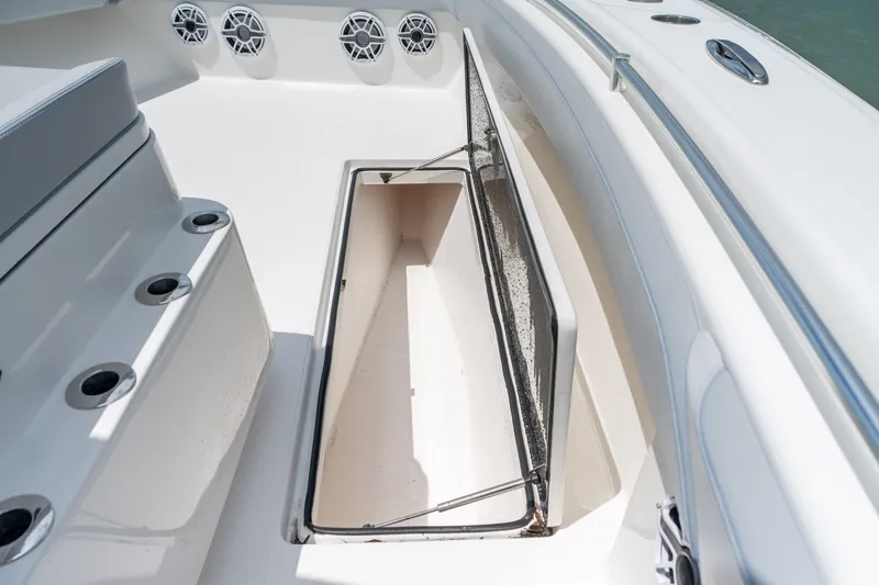 Slide: The Image of Open storage compartment on 2021 SeaHunter 41 CTS boat deck, featuring rod holders and speakers. - 46