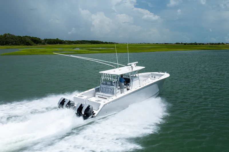 Slide: The Image of 2021 SeaHunter 41 CTS boat cruising on a serene waterway under a cloudy sky. - 16