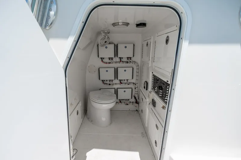Slide: The Image of Interior of 2021 SeaHunter 41 CTS boat featuring a compact marine toilet and control panels. - 53